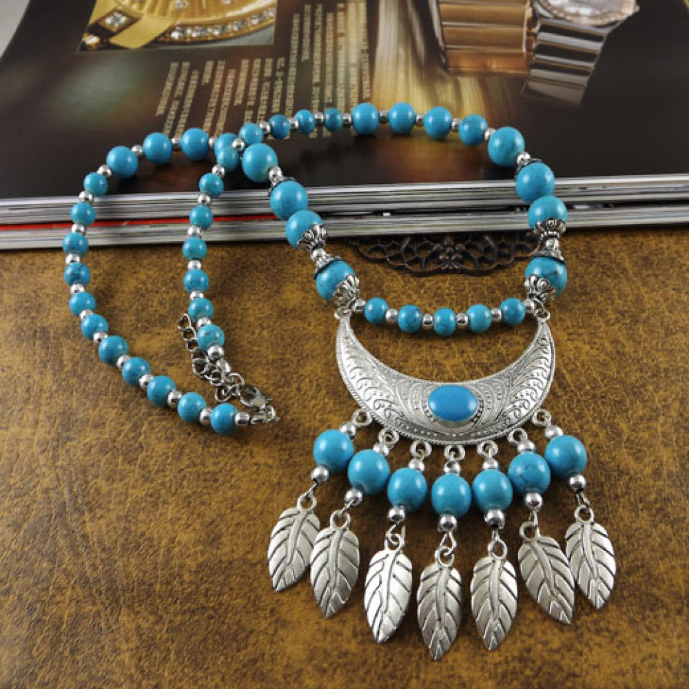 Vintage black beaded necklace with intricate silver-toned leaf tassel and crescent pendant, featuring black beads and gothic tribal design, ideal for bohemian goth fashion, showcased on a textured surface with vintage accents 02