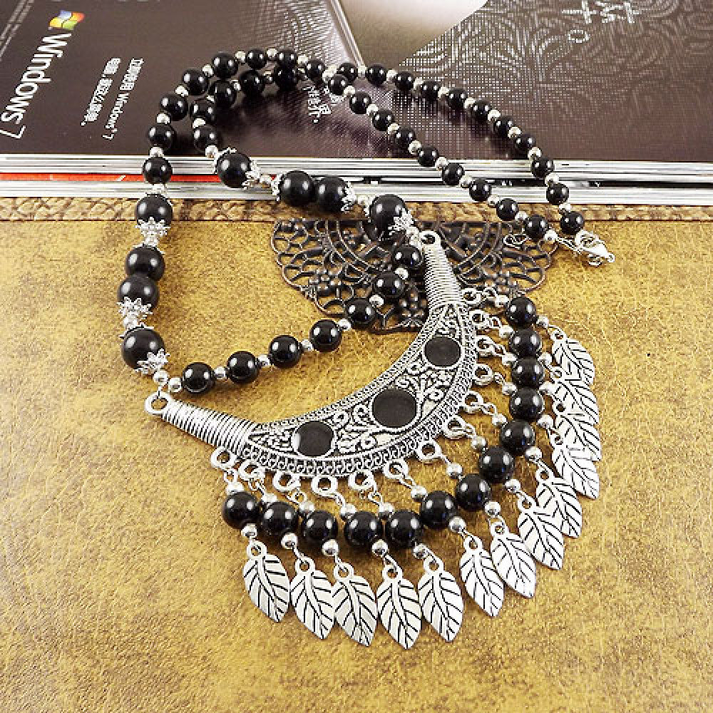 Vintage black beaded necklace with intricate silver-toned leaf tassel and crescent pendant, featuring black beads and gothic tribal design, ideal for bohemian goth fashion, showcased on a textured surface with vintage accents 07
