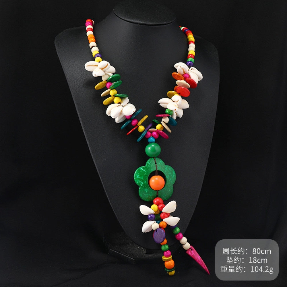 Vintage bohemian colorful shell and beaded necklace with tropical floral pendant, featuring multi-color beads and shell accents, ideal for boho beach and ethnic fashion, displayed on a black mannequin against a dark background