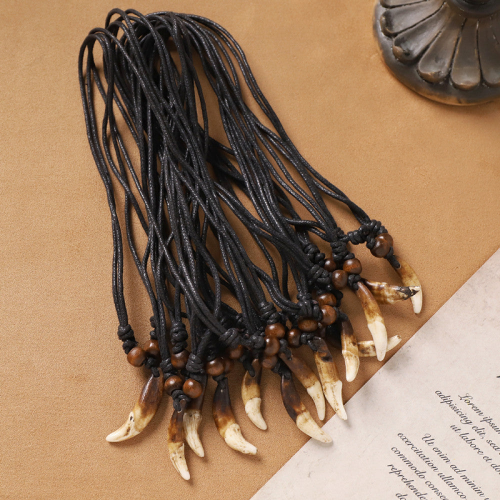 Vintage bohemian ethnic necklace set with animal tooth pendants, black leather cords, and bead accents, displayed against a neutral background with decorative elements, ideal for tribal and boho fashion enthusiasts 