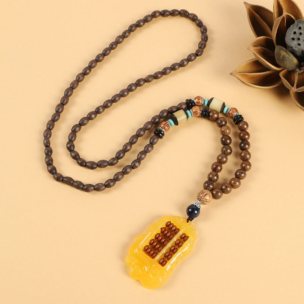 Vintage bohemian ethnic beaded necklace with intricate seed pendant and multi-color beads, ideal for spiritual boho fashion, displayed with a decorative flower against a neutral background 01