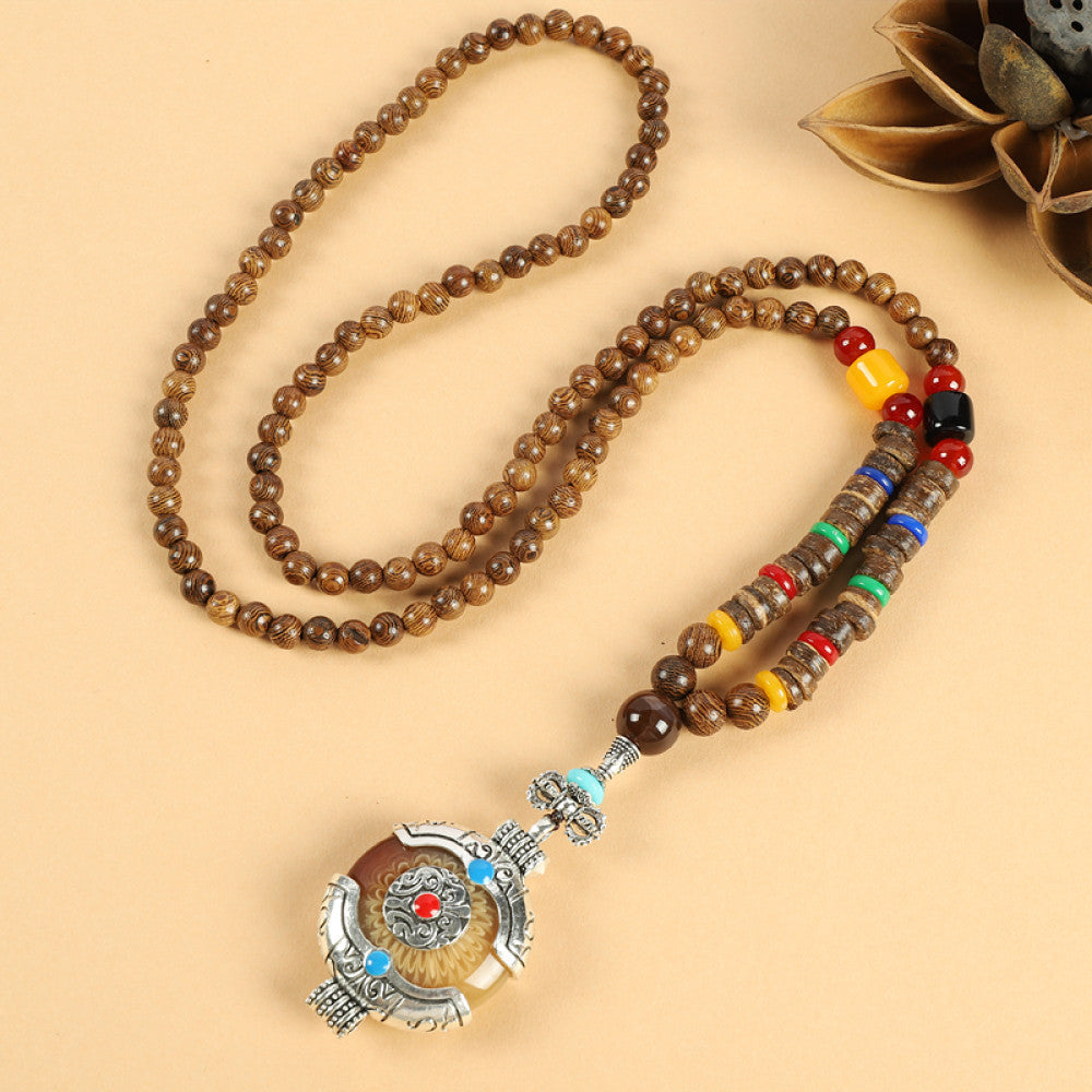 Vintage bohemian ethnic beaded necklace with jade pendant and multi-color beads, ideal for spiritual boho fashion, displayed with a decorative flower against a neutral background 01