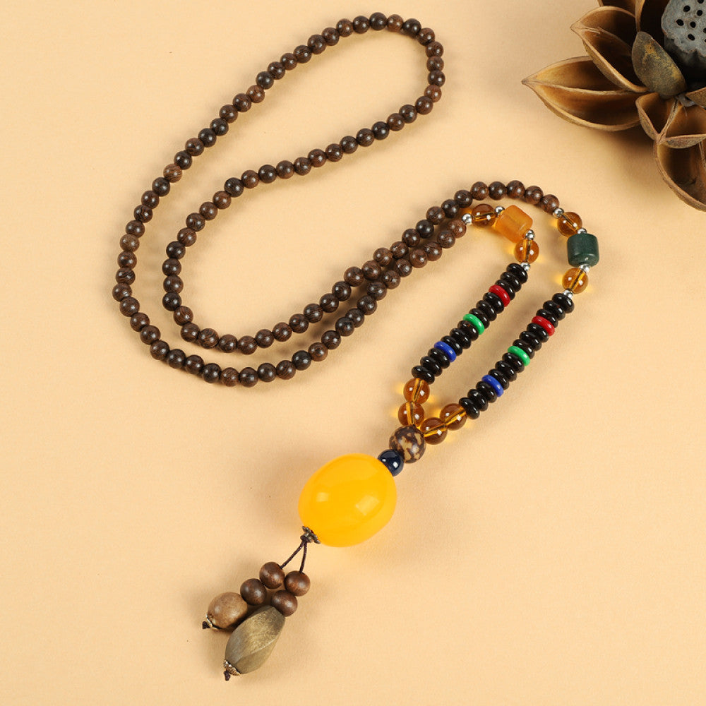 Vintage bohemian ethnic beaded necklace with jade pendant and multi-color beads, ideal for spiritual boho fashion, displayed with a decorative flower against a neutral background 08