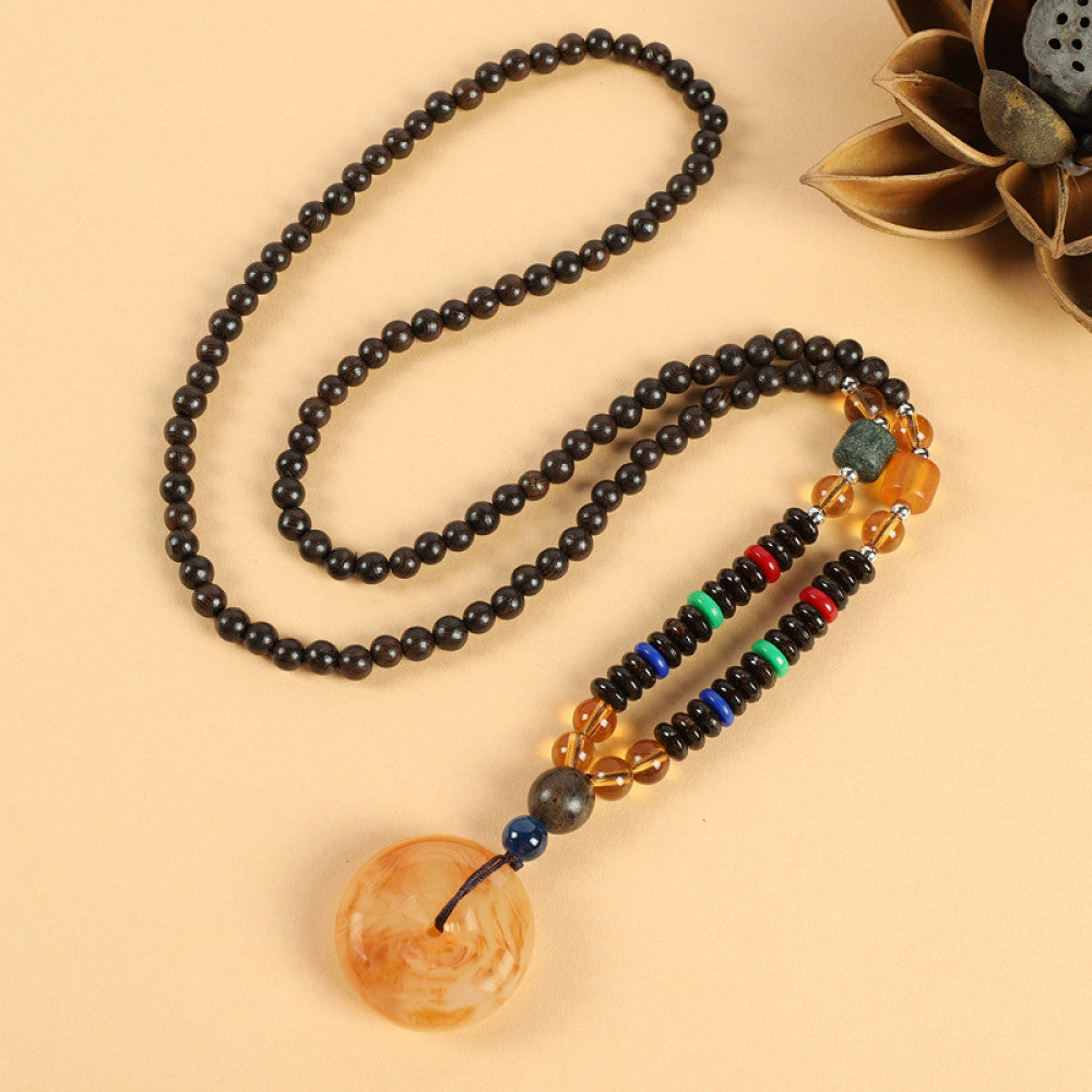 Vintage bohemian ethnic beaded necklace with red pendant and multi-color beads, ideal for spiritual boho fashion, displayed with a decorative flower against a neutral background 02