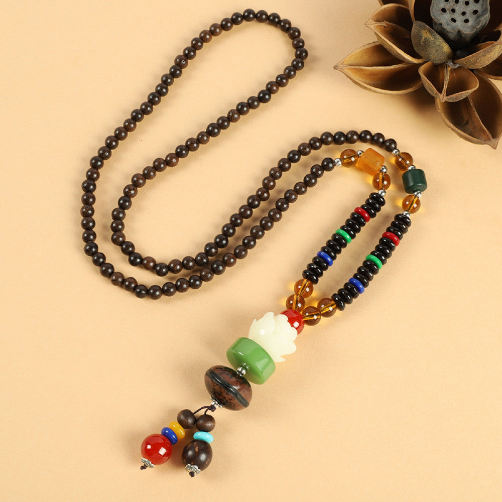 Vintage bohemian ethnic beaded necklace with red pendant and multi-color beads, ideal for spiritual boho fashion, displayed with a decorative flower against a neutral background 04