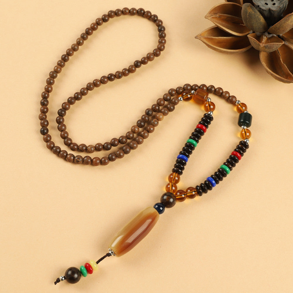 Vintage bohemian ethnic beaded necklace with red pendant and multi-color beads, ideal for spiritual boho fashion, displayed with a decorative flower against a neutral background 06