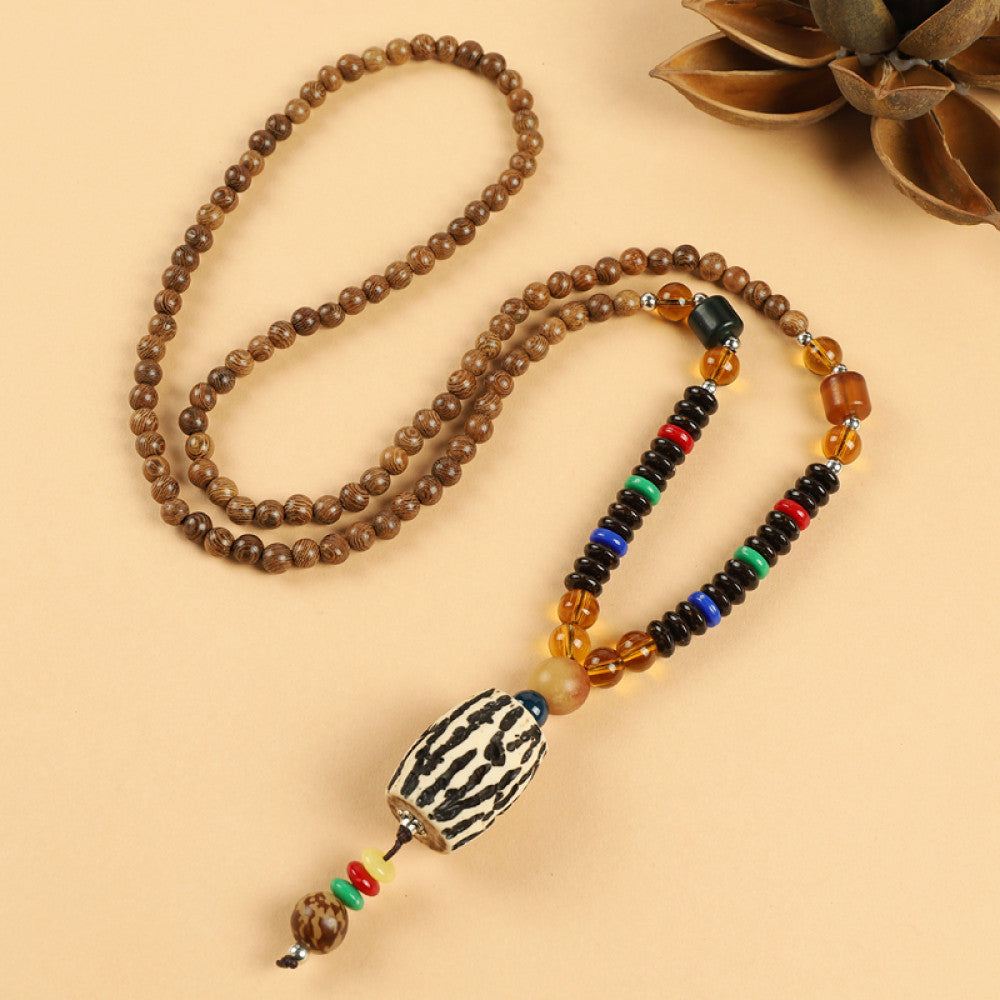 Vintage bohemian ethnic beaded necklace with red pendant and multi-color beads, ideal for spiritual boho fashion, displayed with a decorative flower against a neutral background 08