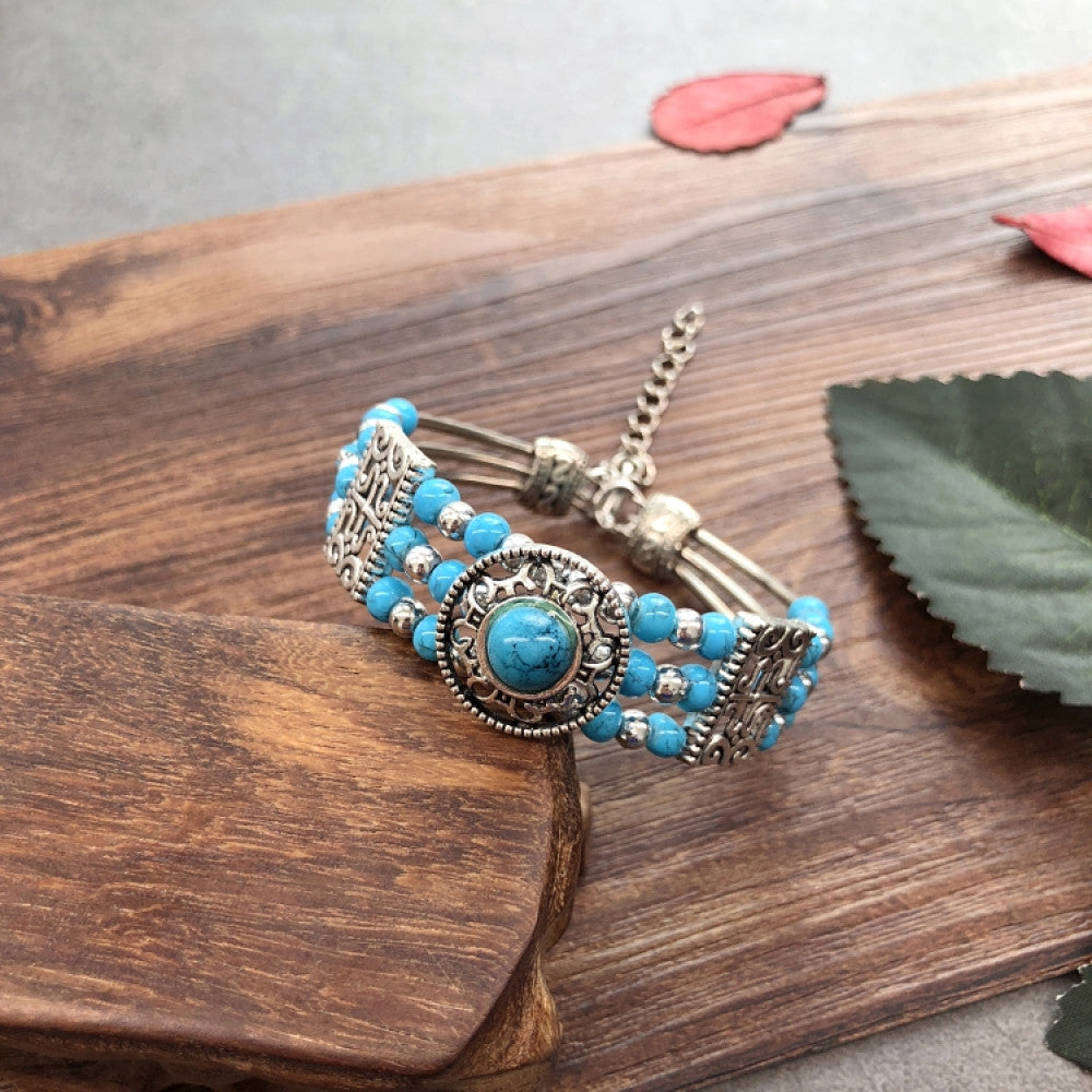 Vintage bohemian ethnic black beaded bracelet with silver engraved accents, displayed on a wooden surface, ideal for boho fashion enthusiasts