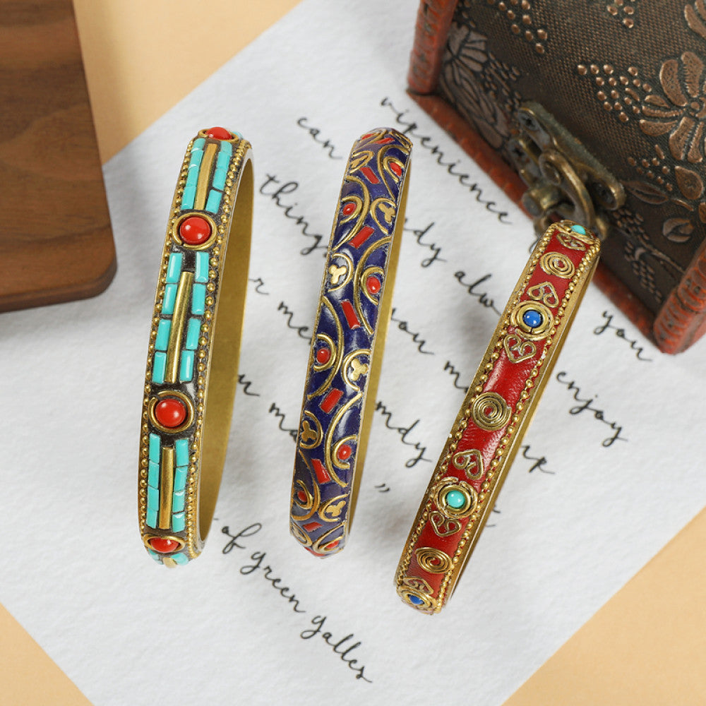 Vintage bohemian ethnic enamel bangle set with colorful stone inlays in turquoise, blue, and red designs, displayed on paper with a vintage box, ideal for boho fashion enthusiasts