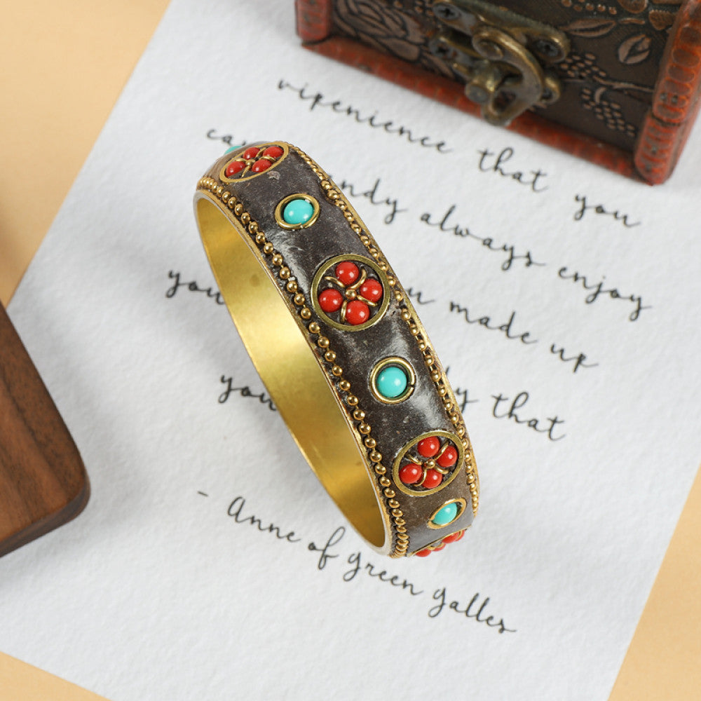 Vintage bohemian ethnic enamel bangle with turquoise and red stone inlays, gold-tone textured design, displayed on paper with decorative text and a vintage box, ideal for boho fashion enthusiasts 03