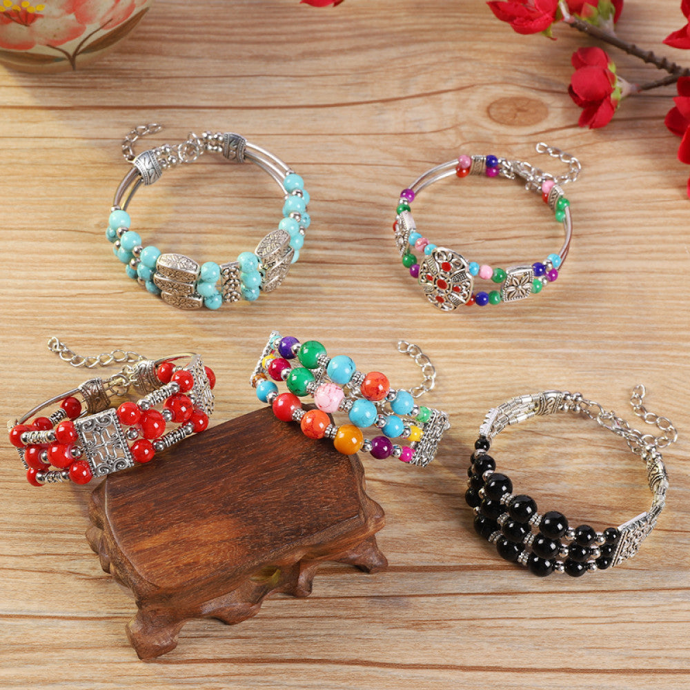 Assorted bohemian vintage ethnic beaded bracelet set with turquoise, multi-color, red, black bead designs and silver accents, displayed on a wooden surface, ideal for boho fashion enthusiasts
