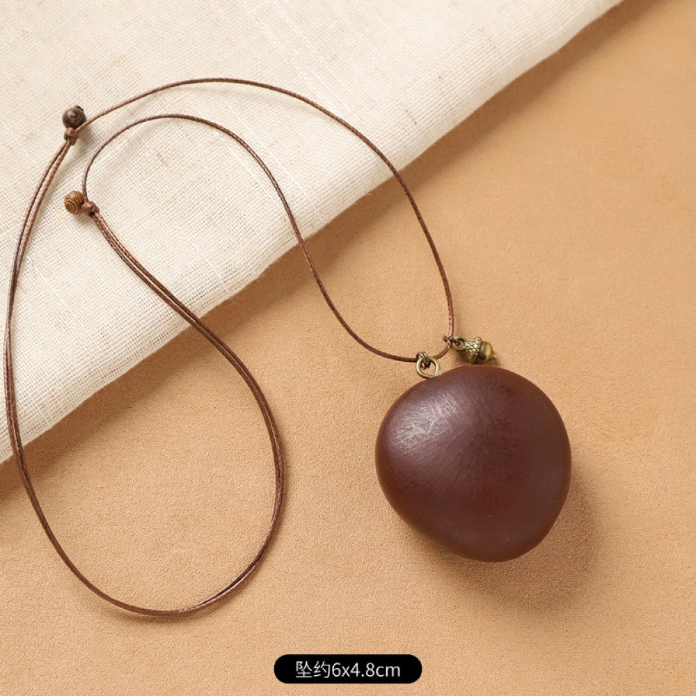 Vintage bohemian ethnic necklace with round natural stone pendant, featuring earthy brown tones and cord design, displayed on a neutral background with linen accent, ideal for boho fashion enthusiasts