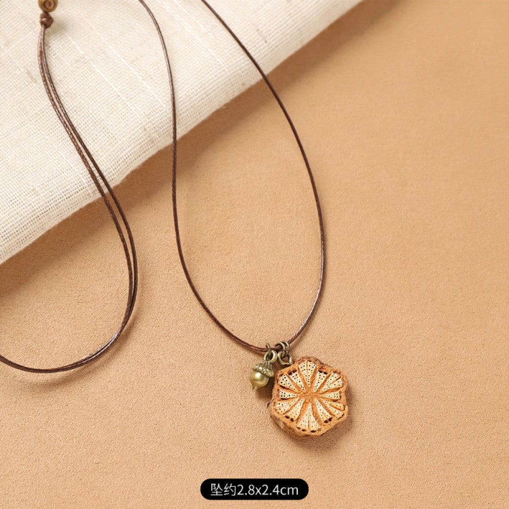 Vintage bohemian ethnic necklace with natural seed pendant, featuring earthy brown tones and cord design, displayed on a white plate against a neutral background, ideal for boho fashion enthusiasts 03