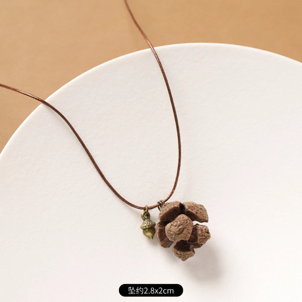 Vintage bohemian ethnic necklace with natural seed pendant, featuring earthy brown tones and cord design, displayed on a white plate against a neutral background, ideal for boho fashion enthusiasts 08