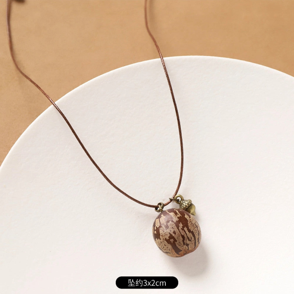 Vintage bohemian ethnic necklace with natural seed pendant, featuring earthy brown tones and cord design, displayed on a white plate against a neutral background, ideal for boho fashion enthusiasts 12