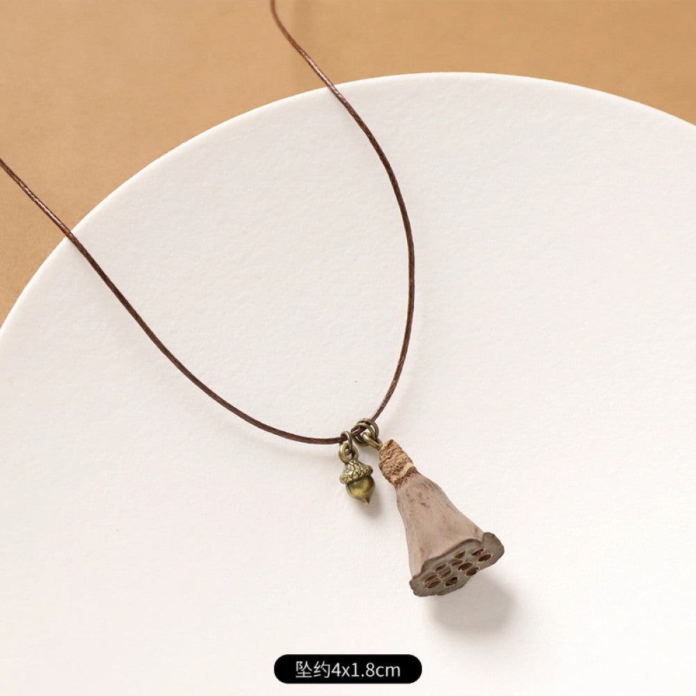 Vintage bohemian ethnic necklace with natural seed pendant, featuring earthy brown tones and cord design, displayed on a white plate against a neutral background, ideal for boho fashion enthusiasts 15