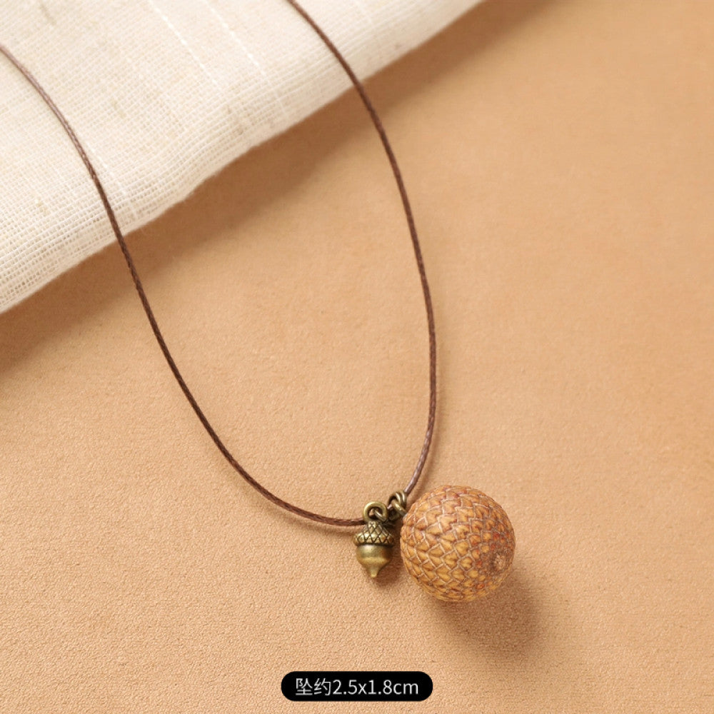 Vintage bohemian ethnic necklace with natural seed pendant, featuring earthy brown tones and cord design, displayed on a white plate against a neutral background, ideal for boho fashion enthusiasts 16