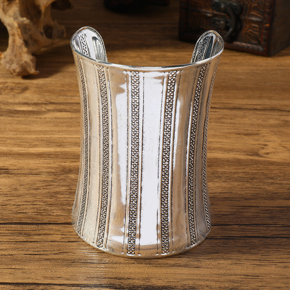 Vintage bohemian ethnic silver-tone engraved cuff bracelet with ornate tribal designs, displayed on a wooden surface with decorative elements, ideal for boho and ethnic fashion enthusiasts 01