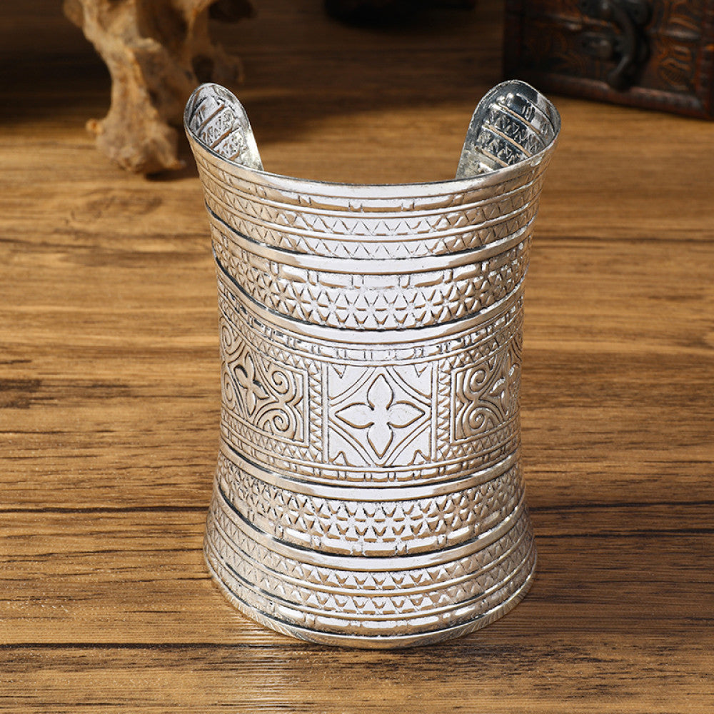 Vintage bohemian ethnic silver-tone engraved cuff bracelet with ornate tribal designs, displayed on a wooden surface with decorative elements, ideal for boho and ethnic fashion enthusiasts 0