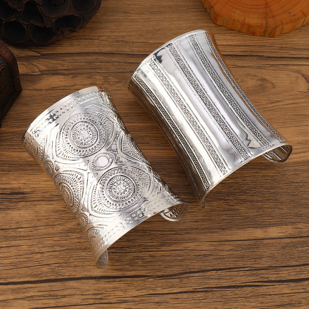 Vintage bohemian ethnic silver-tone engraved cuff bracelet set with ornate tribal designs, displayed on a wooden surface, ideal for boho and ethnic fashion enthusiasts