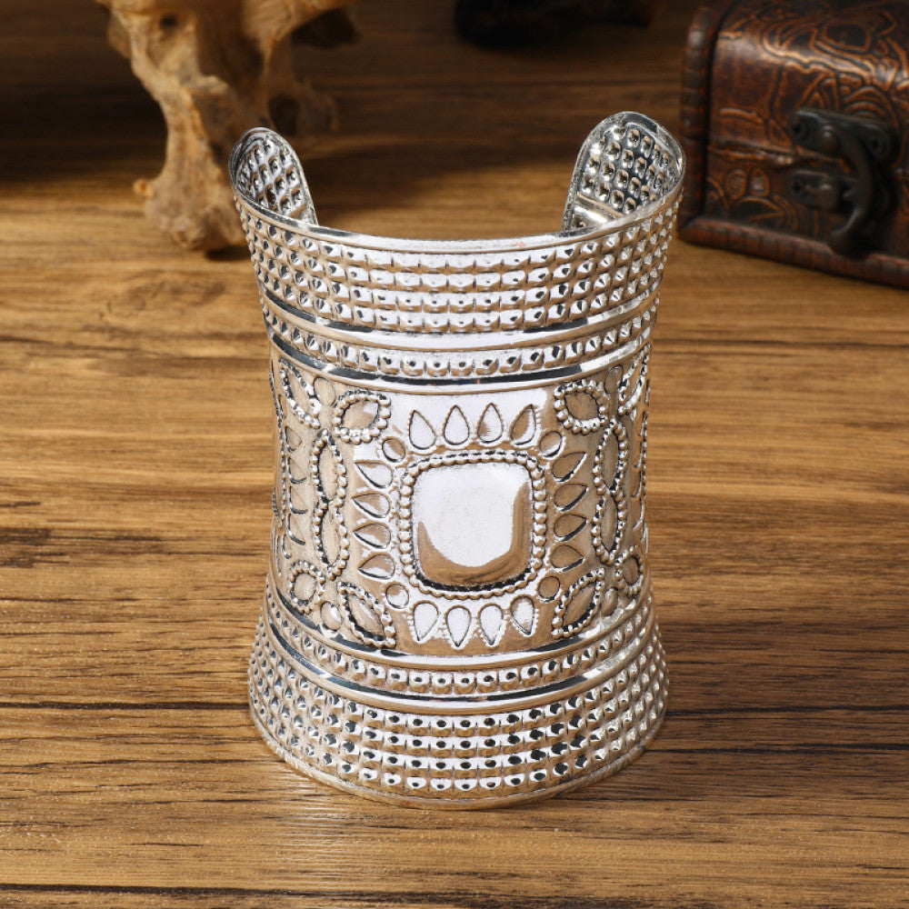 Vintage bohemian ethnic silver-tone cuff bracelet with intricate tribal animal engravings, displayed on a wooden surface with decorative elements, ideal for boho and ethnic fashion enthusiasts 04