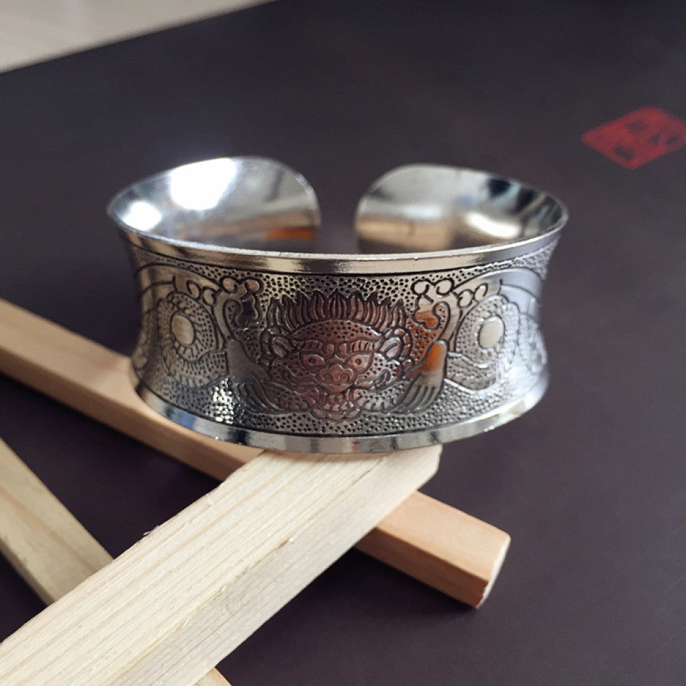 Vintage bohemian ethnic silver-tone engraved filigree cuff bracelet with intricate floral designs, displayed on wooden accents, ideal for boho and ethnic fashion enthusiasts 03