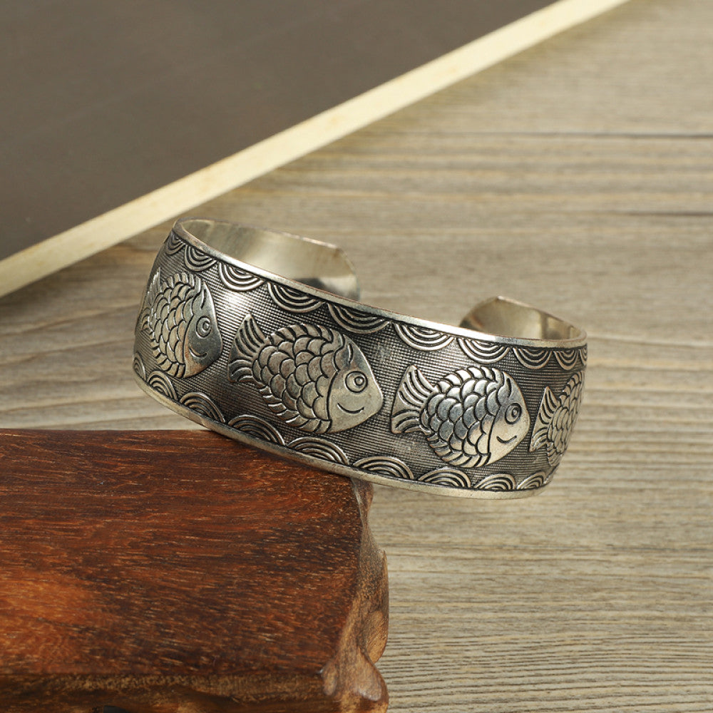 Vintage bohemian ethnic silver-tone engraved filigree cuff bracelet with intricate floral designs, displayed on wooden accents, ideal for boho and ethnic fashion enthusiasts 08