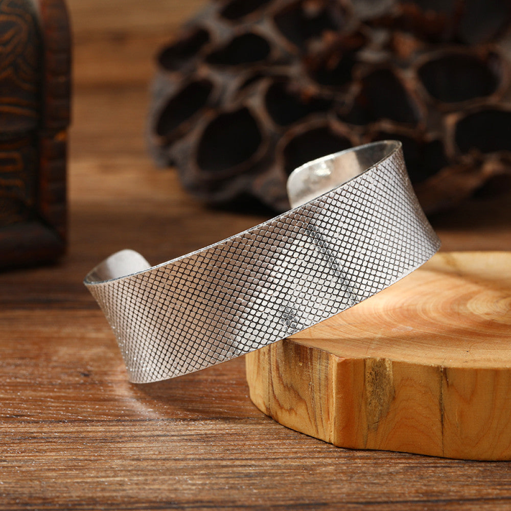 Vintage bohemian ethnic silver-tone cuff bracelet with intricate engraved floral designs, displayed on a wooden surface with rustic decor, ideal for boho and ethnic fashion enthusiasts 07