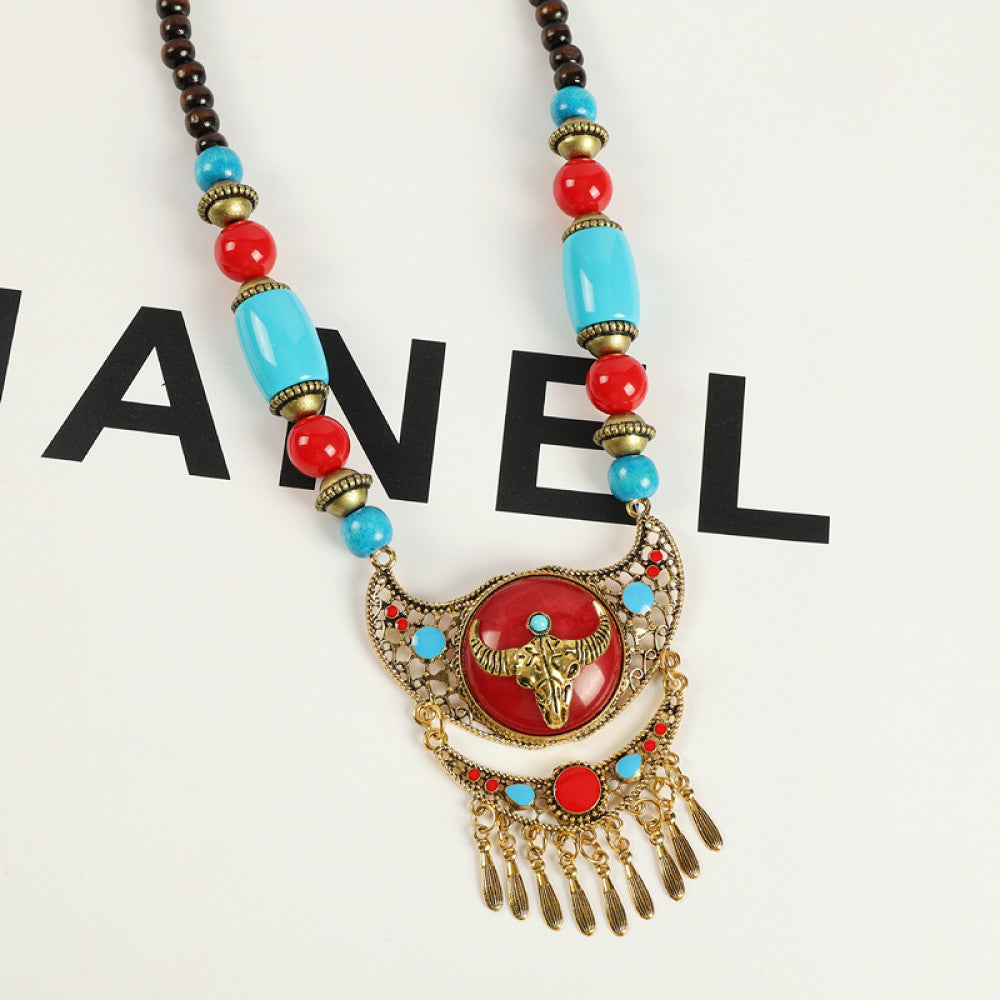 Vintage bohemian ethnic necklace with red pendant, turquoise accents, and tassel design, featuring antique bronze details, displayed against a black background with fashion text and Eiffel Tower accent, ideal for boho fashion enthusiasts 03