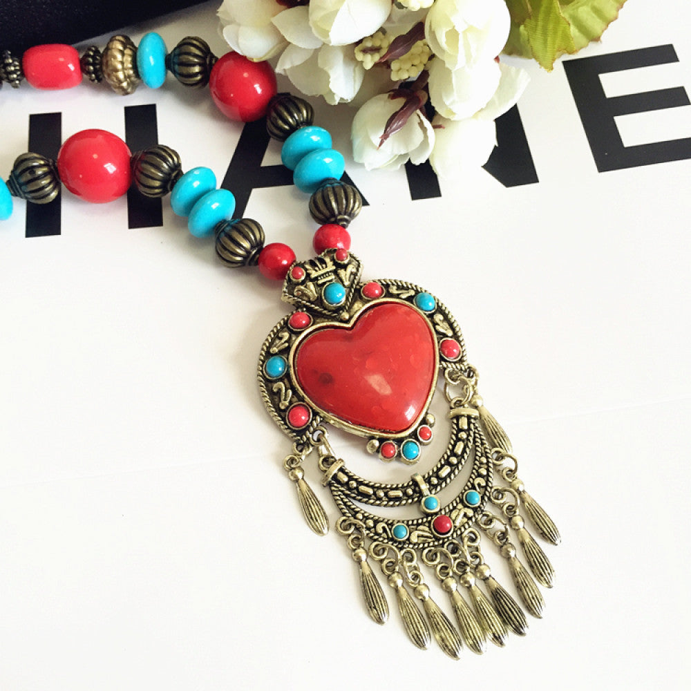 Vintage bohemian ethnic necklace with red pendant, turquoise accents, and tassel design, featuring antique bronze details, displayed against a black background with fashion text and Eiffel Tower accent, ideal for boho fashion enthusiasts 05