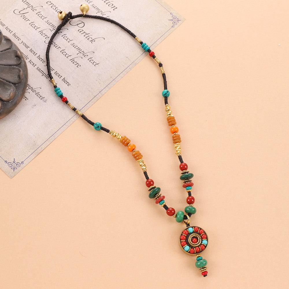 Vintage bohemian ethnic tribal beaded necklace with intricate colorful pendant and multi-color beads, ideal for boho fashion, displayed on a neutral background with vintage paper accent 02