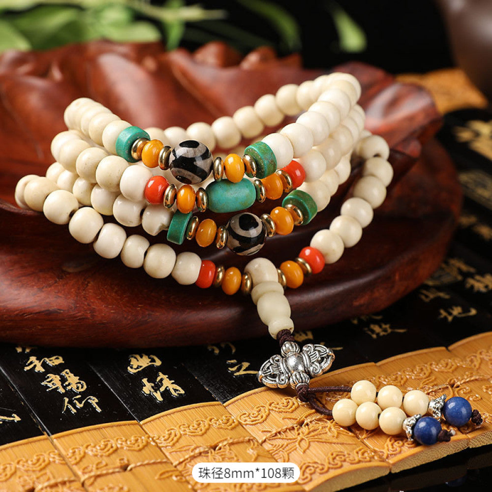 Vintage bohemian ethnic tribal multi-layer beaded necklace with turquoise accents and red tassels, displayed on an old book, ideal for spiritual boho fashion and layering 01