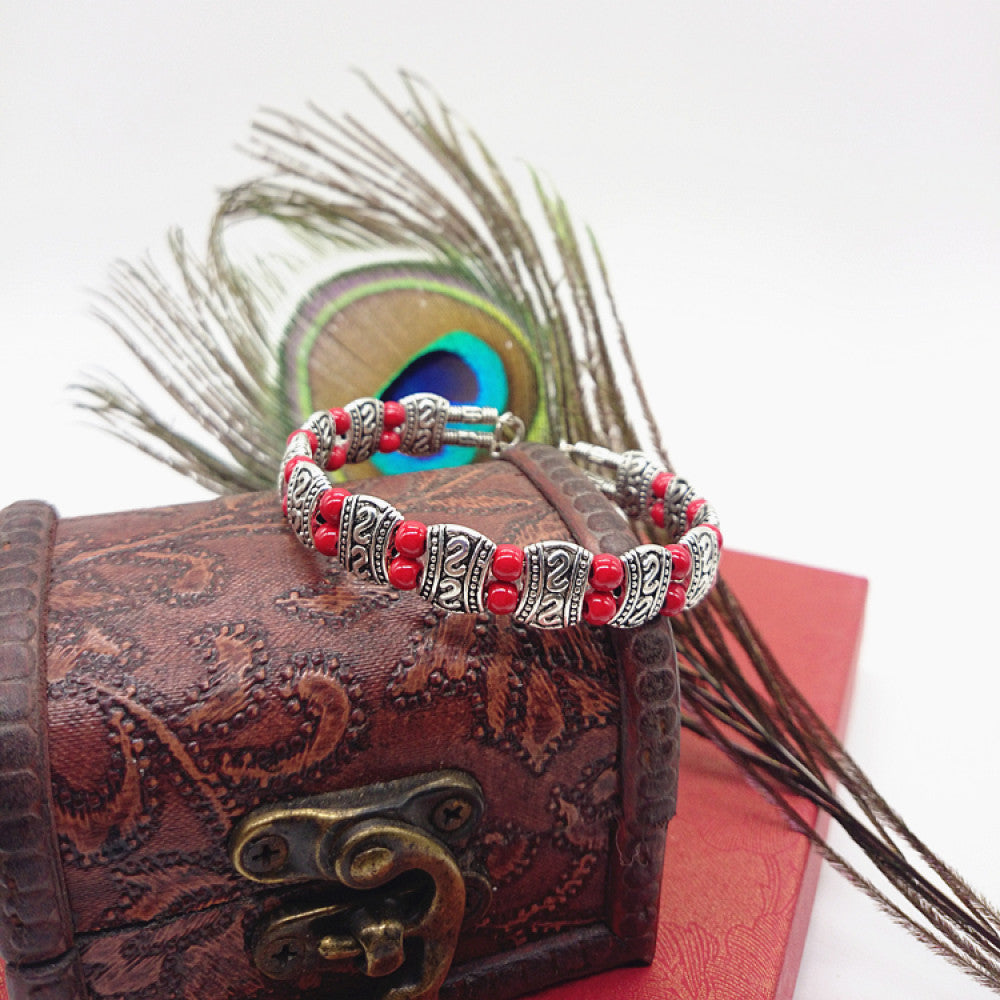 Vintage bohemian ethnic turquoise beaded bracelet with silver engraved accents, displayed on a patterned vintage box with peacock feathers, ideal for boho and ethnic fashion enthusiasts 02