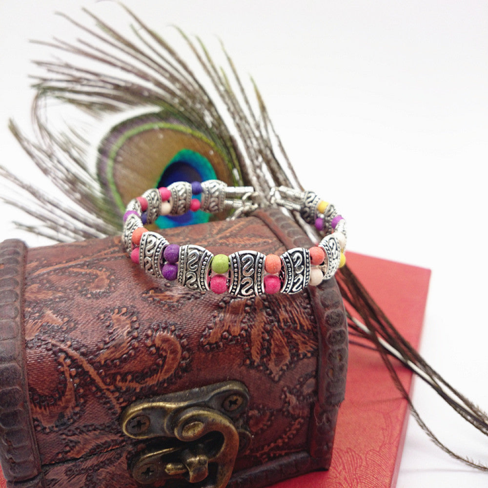Vintage bohemian ethnic turquoise beaded bracelet with silver engraved accents, displayed on a patterned vintage box with peacock feathers, ideal for boho and ethnic fashion enthusiasts 03