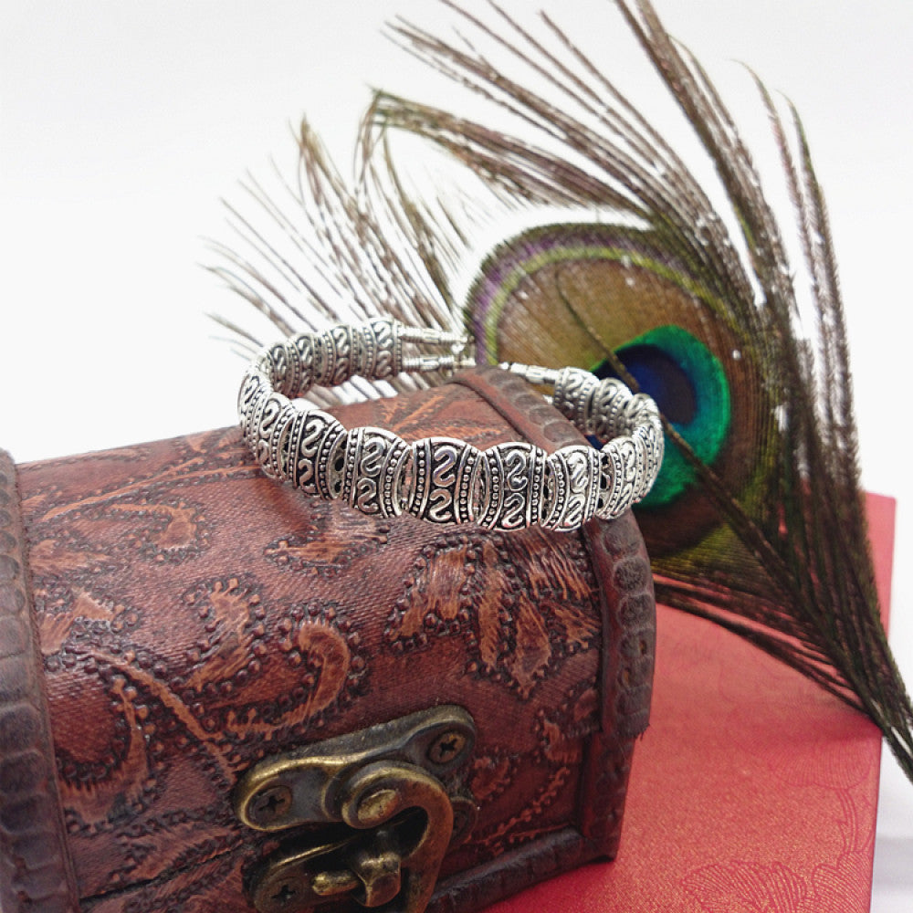 Vintage bohemian ethnic turquoise beaded bracelet with silver engraved accents, displayed on a patterned vintage box with peacock feathers, ideal for boho and ethnic fashion enthusiasts 06