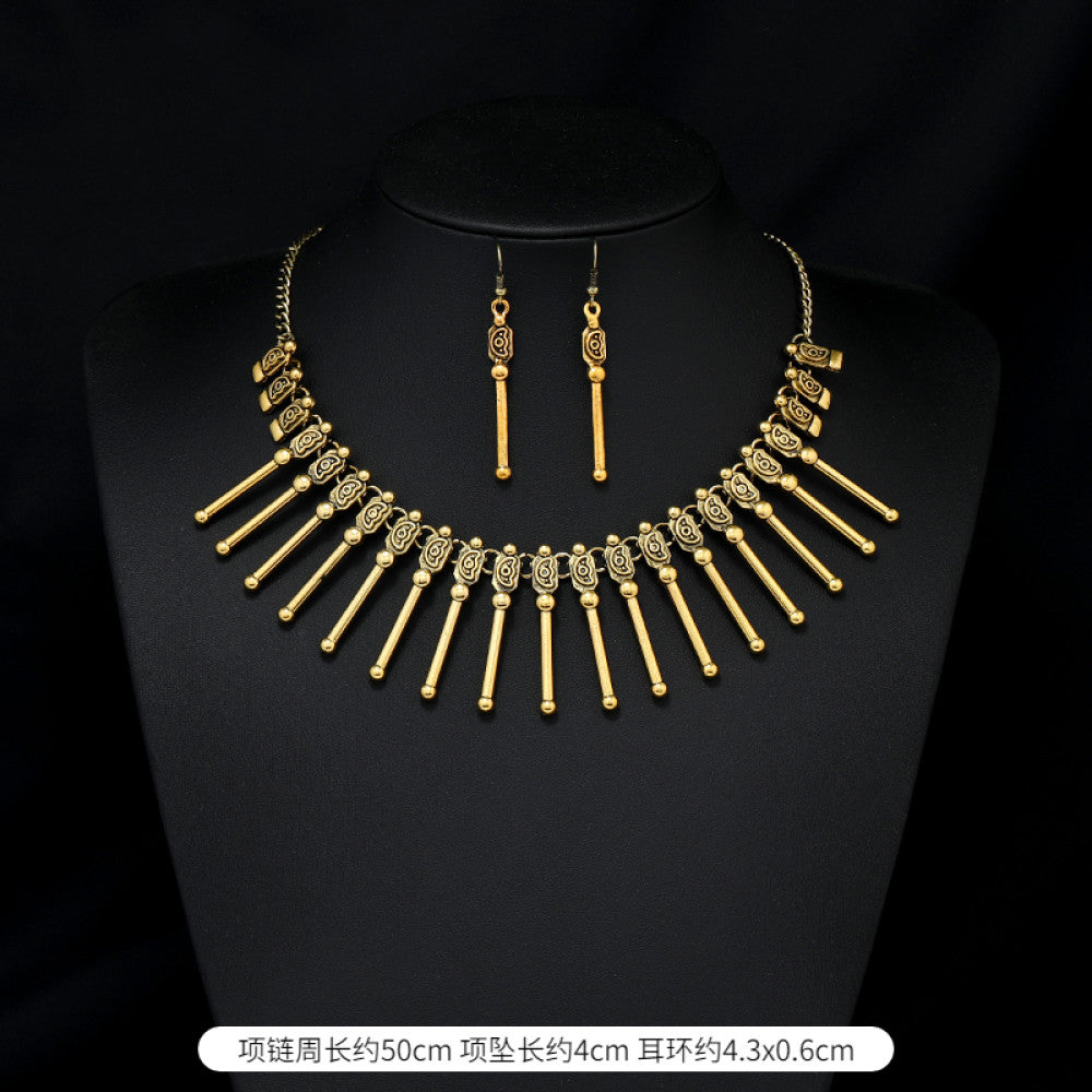 Vintage bohemian ethnic gold-tone necklace and earring set with intricate jhumka design, ideal for traditional or boho-chic occasions, displayed on a black mannequin against a dark background 02