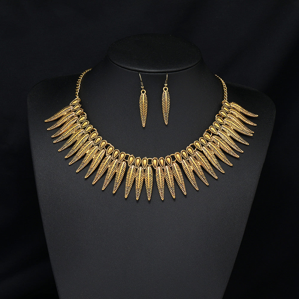 Vintage bohemian ethnic gold-tone necklace and earring set with intricate jhumka design, ideal for traditional or boho-chic occasions, displayed on a black mannequin against a dark background 04