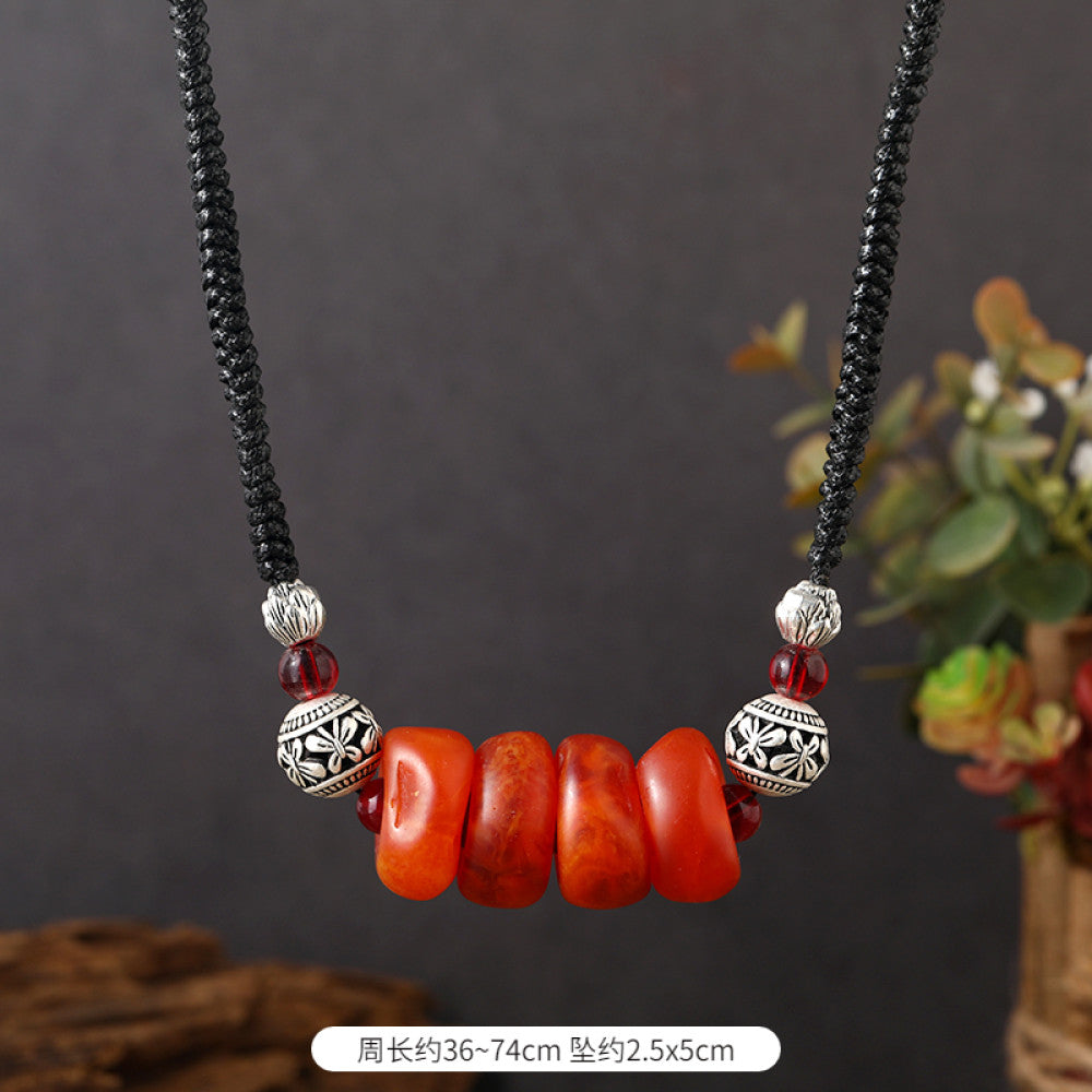 Vintage bohemian ethnic tribal necklace featuring a red circular pendant, intricate silver detailing, and braided rope design, perfect for boho fashion, showcased against a neutral background 01