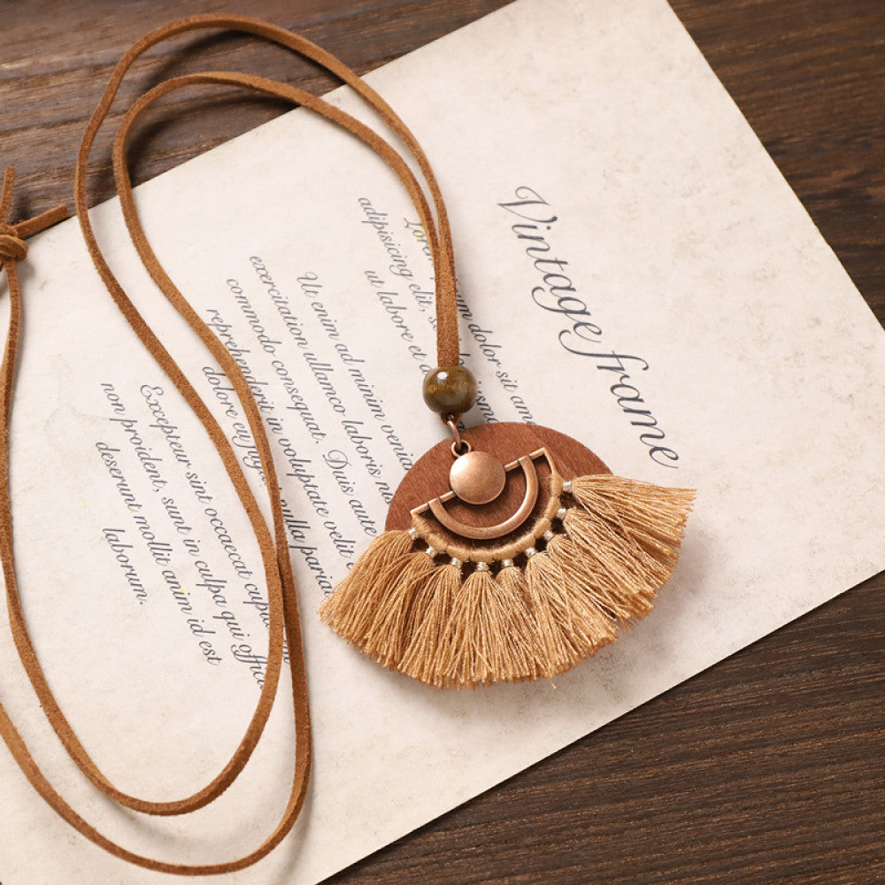 Vintage bohemian tassel necklace with earthy tone fringe and intricate pendant, displayed on vintage paper, ideal for boho fashion enthusiasts 02