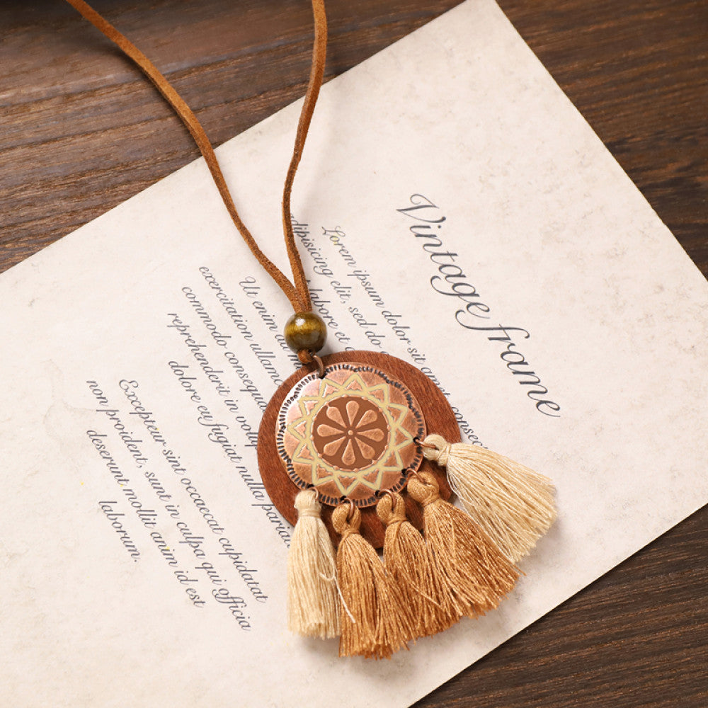 Vintage bohemian tassel necklace with earthy tone fringe and intricate pendant, displayed on vintage paper, ideal for boho fashion enthusiasts 04