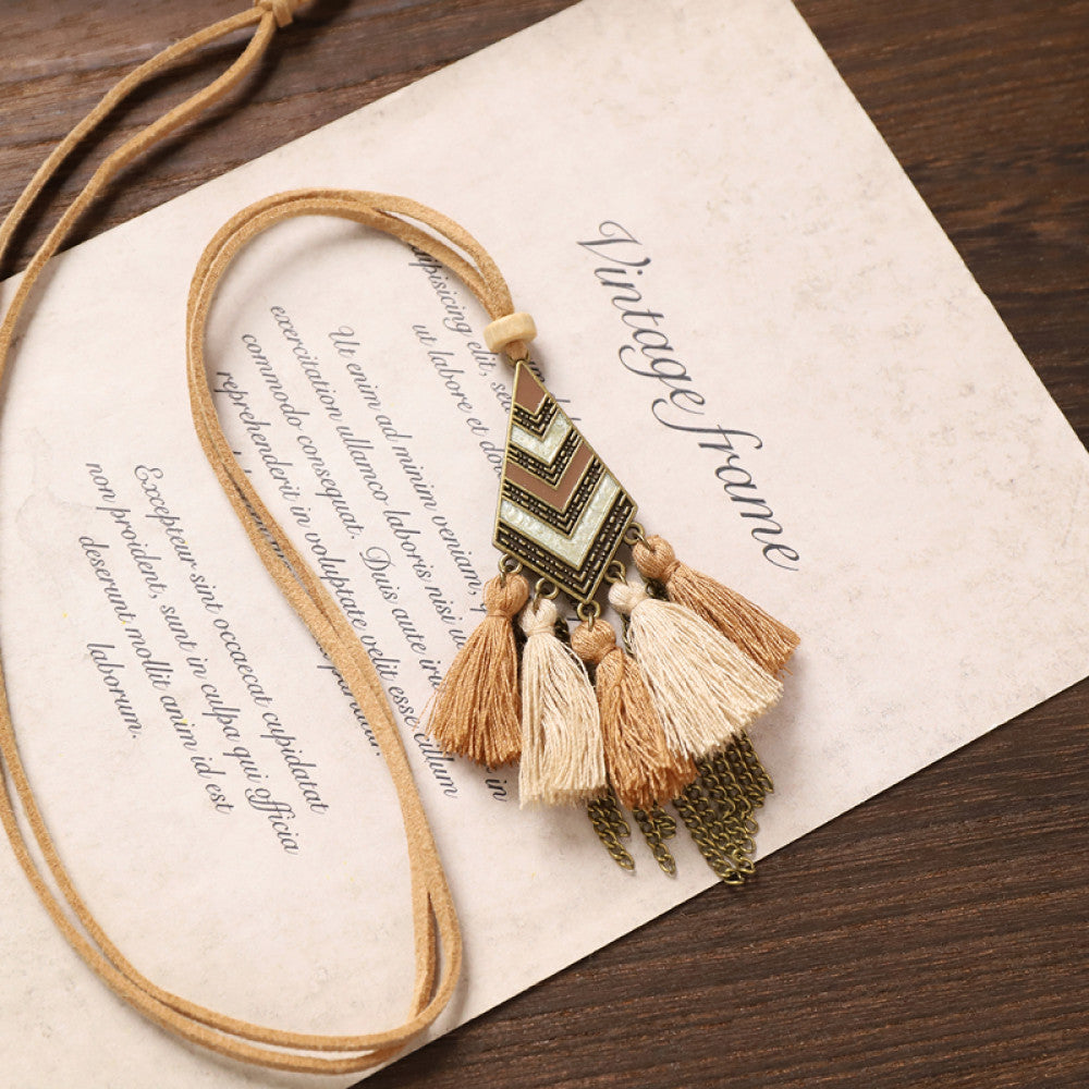 Vintage bohemian tassel necklace with earthy tone fringe and intricate pendant, displayed on vintage paper, ideal for boho fashion enthusiasts 06