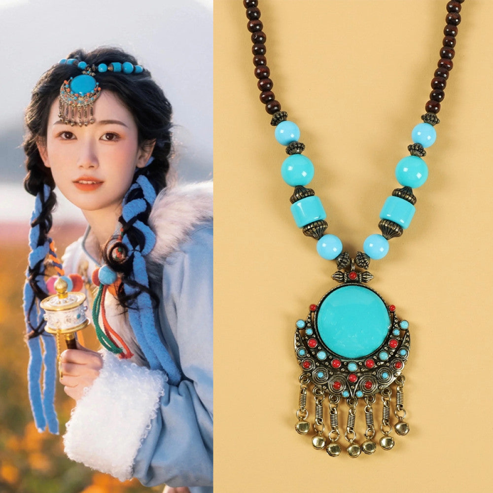 Ethnic tribal style necklace with large turquoise pendant, blue beaded design, and tassel details, perfect for bohemian vintage fashion, showcased alongside a model in traditional ethnic attire