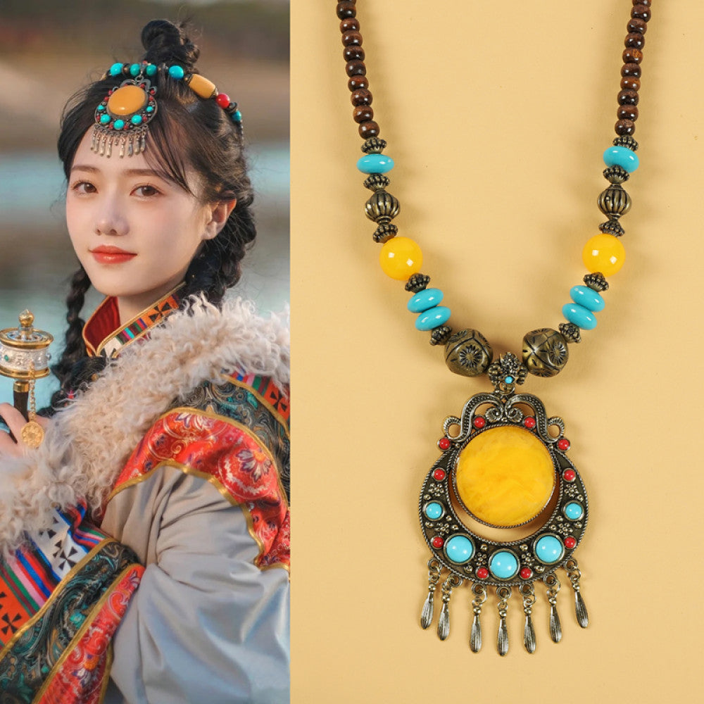 Ethnic tribal style necklace with large yellow pendant, colorful beaded design, and tassel details, ideal for bohemian vintage fashion, displayed alongside a model in traditional ethnic attire