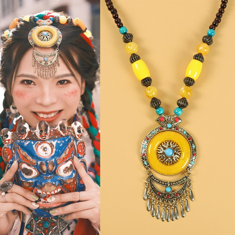 Ethnic tribal style necklace with large yellow pendant, colorful beaded design, and tassel details, ideal for bohemian vintage fashion, displayed alongside a model in traditional ethnic attire
