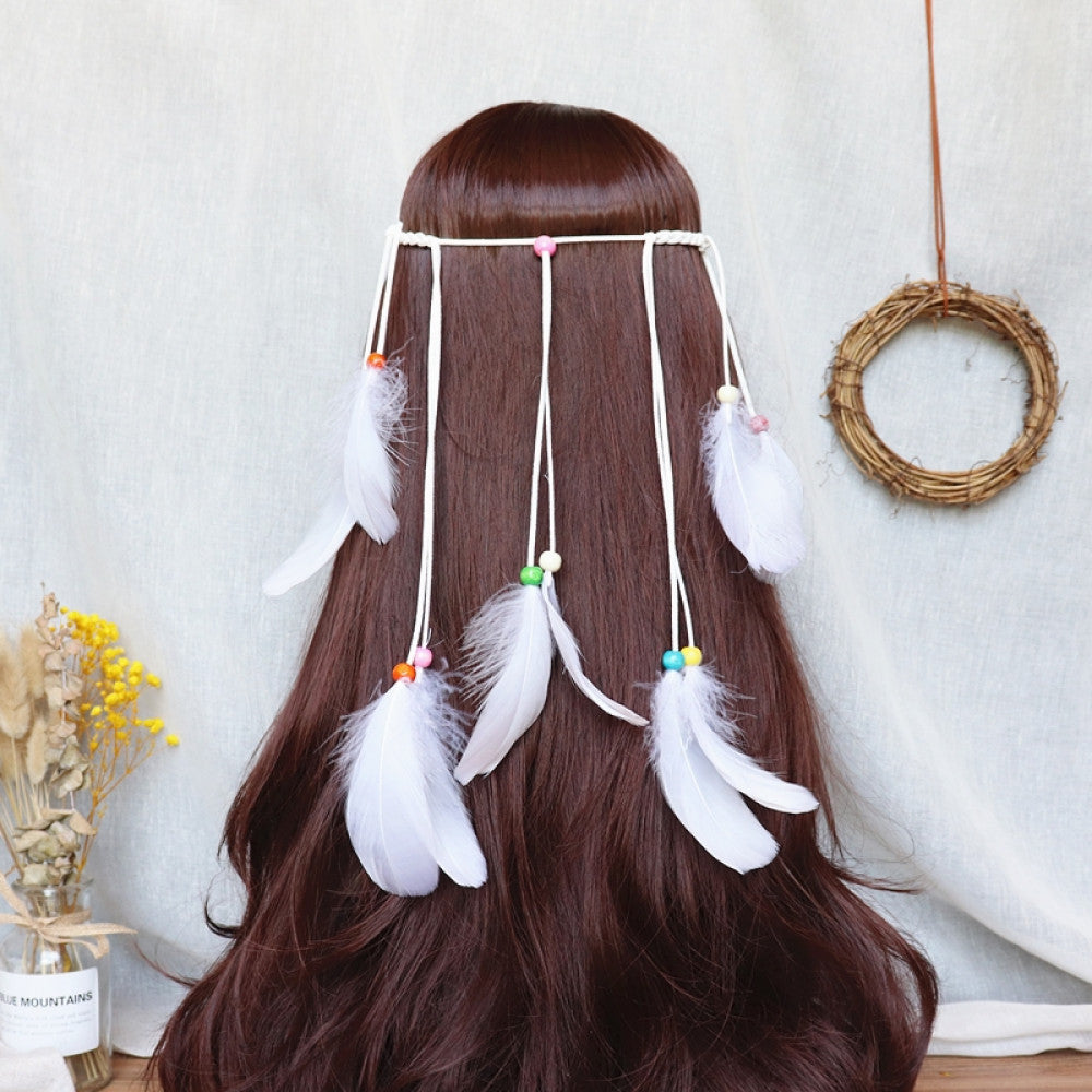 Boho bohemian macramé hair band (worn on long dark brown hair) featuring abundant white feather tassels, wooden bead accents, displayed with dried flower vase & woven wreath decor 03