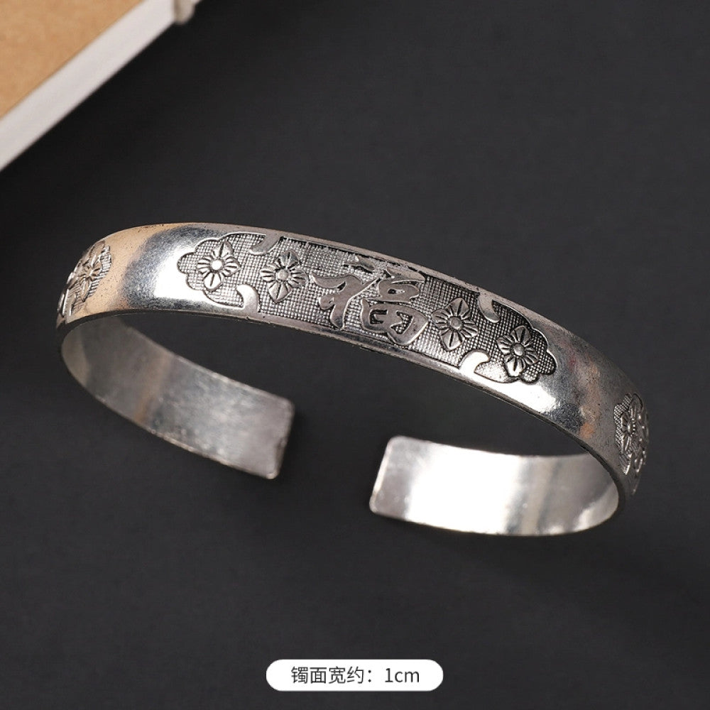 Vintage boho chic silver-tone filigree cuff bracelet with intricate floral designs, styled on a black surface, perfect for bohemian and ethnic fashion lovers in the US 03