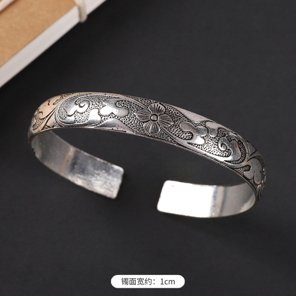 Vintage boho chic silver-tone filigree cuff bracelet with intricate floral designs, styled on a black surface, perfect for bohemian and ethnic fashion lovers in the US 09