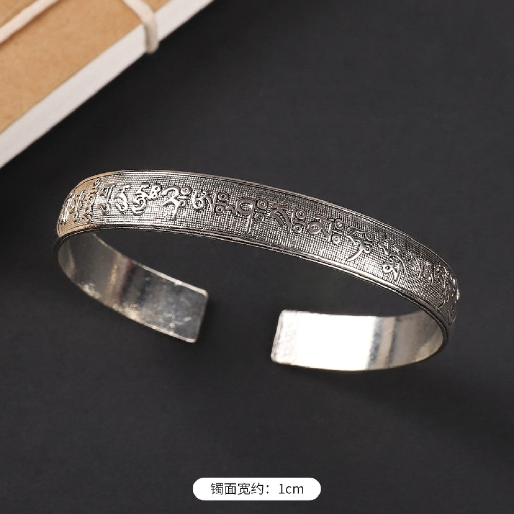 Vintage boho chic silver-tone filigree cuff bracelet with intricate floral designs, styled on a black surface, perfect for bohemian and ethnic fashion lovers in the US 12