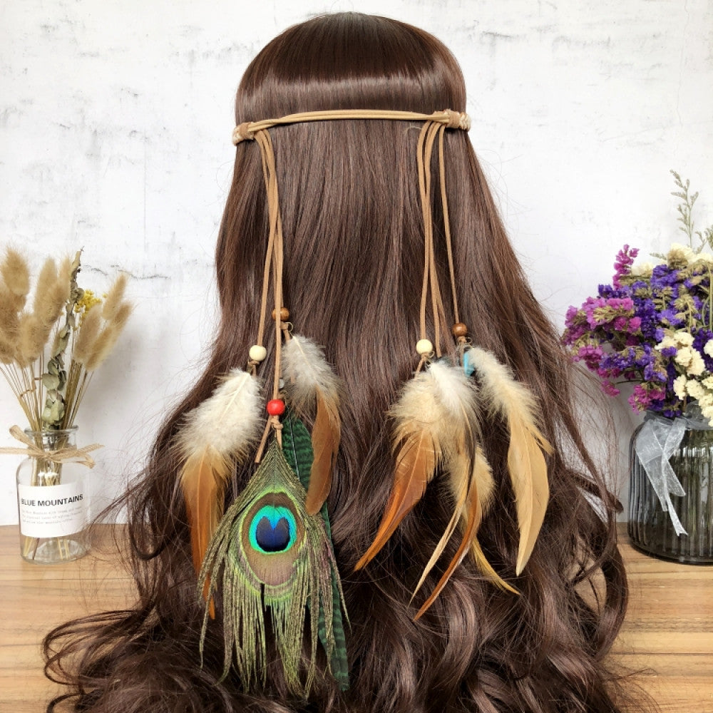 Boho leather cord hair band featuring a vibrant peacock feather, multi color feather tassels, and bead accents  displayed on a wooden surface with dried fresh flower arrangements, ideal for bohemian festival fashion enthusiasts in the US