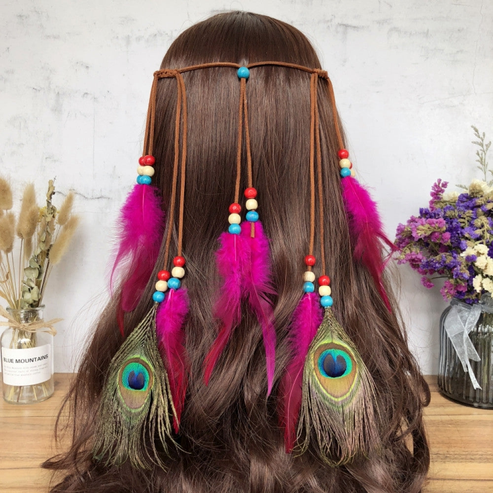 Boho leather cord hair band featuring a vibrant peacock feather, multi color feather tassels, and bead accents  displayed on a wooden surface with dried fresh flower arrangements 11